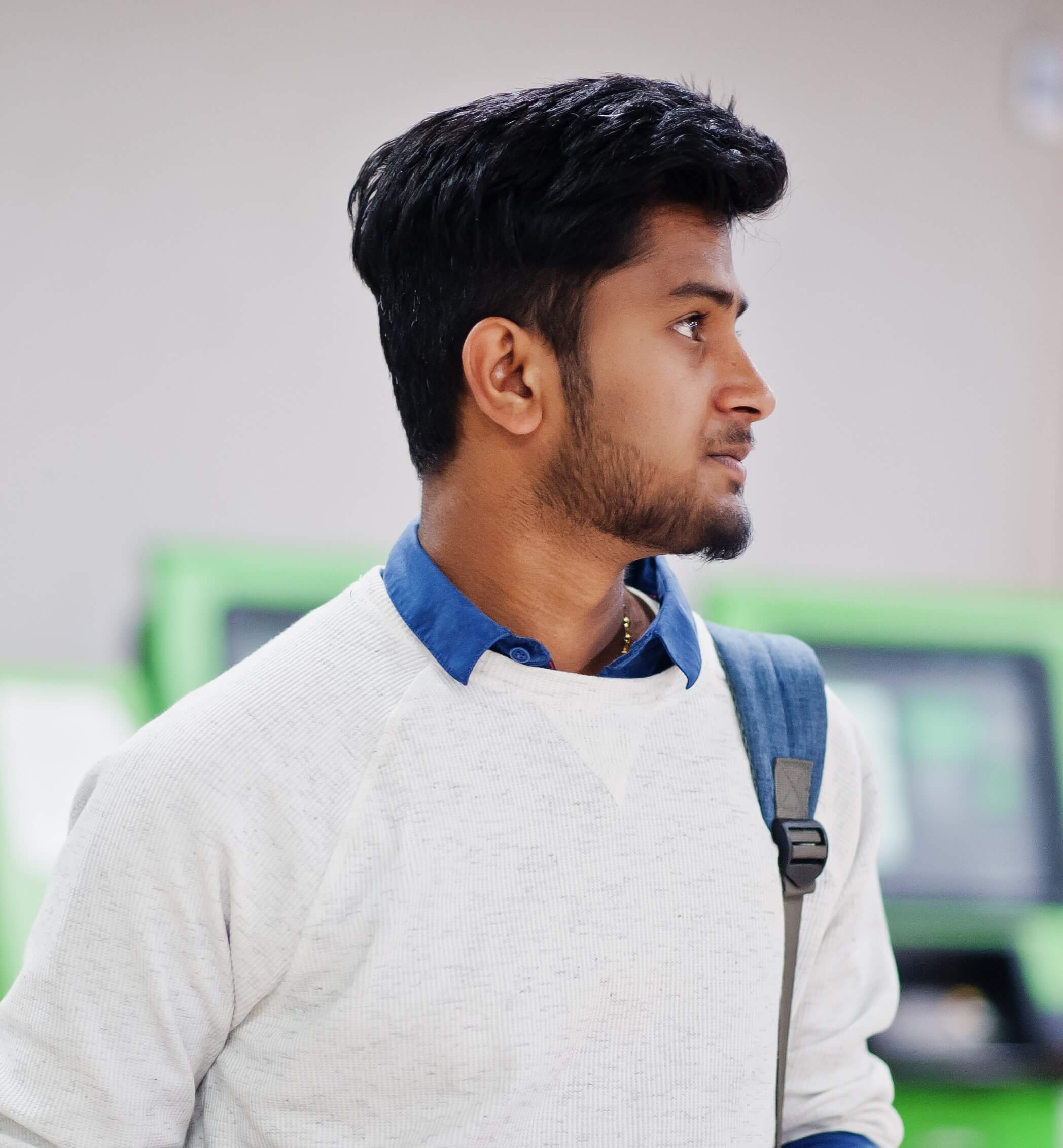 youngstylishasianmanwithmobilephonebackpackagainstrowgreenatm_cwndq_2096