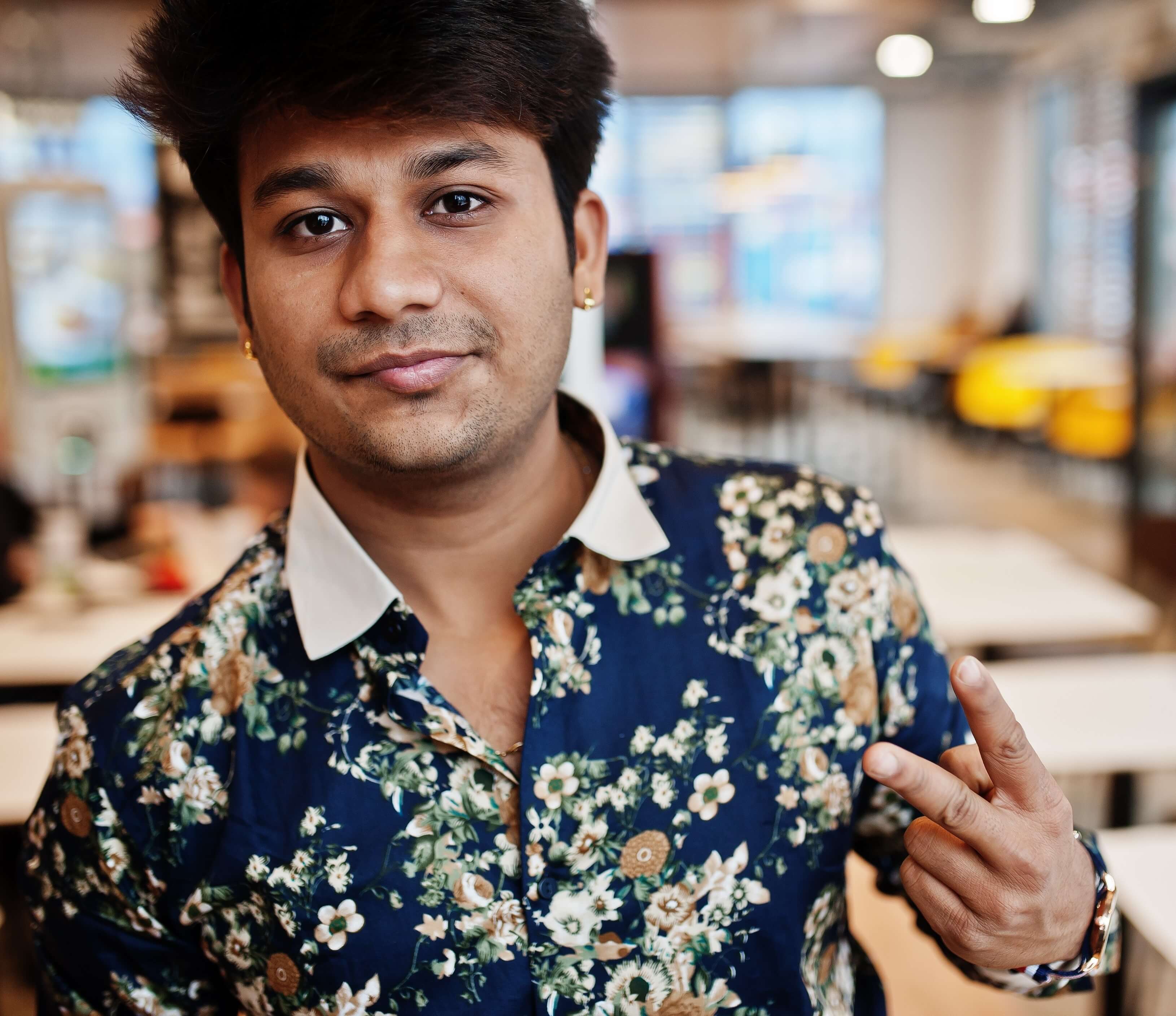 closeupportraityoungmaleindianfreelancerfastfoodcafehandsomeheadasianmanwearshirtcomfortablecoffeeshopshowstwofingerssign_bjui5_3258
