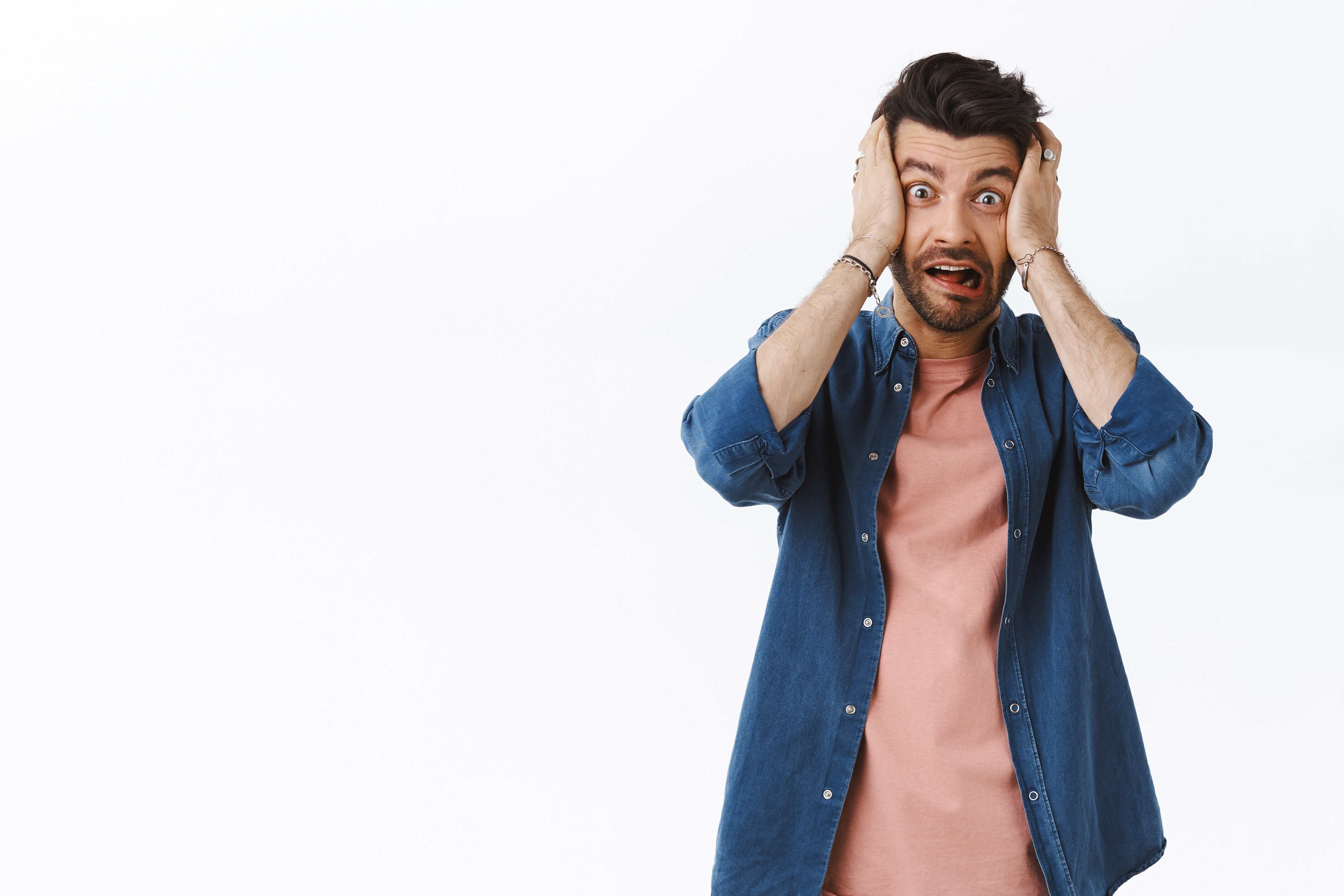 q2odu_5120_shockedfreakoutalarmedyoungbeardedguyscreampanicgrabheadhandsstarecamerascaredanxiousaboutbadconsequenceshavehugetroublenervouslystandingwhitebackground1