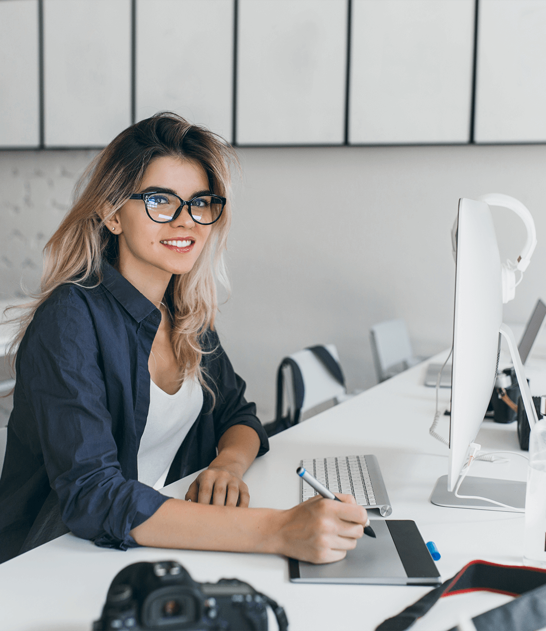 a2mtg_1110_attractivefemaledesignerusingtabletworksittingofficewithlightinterior