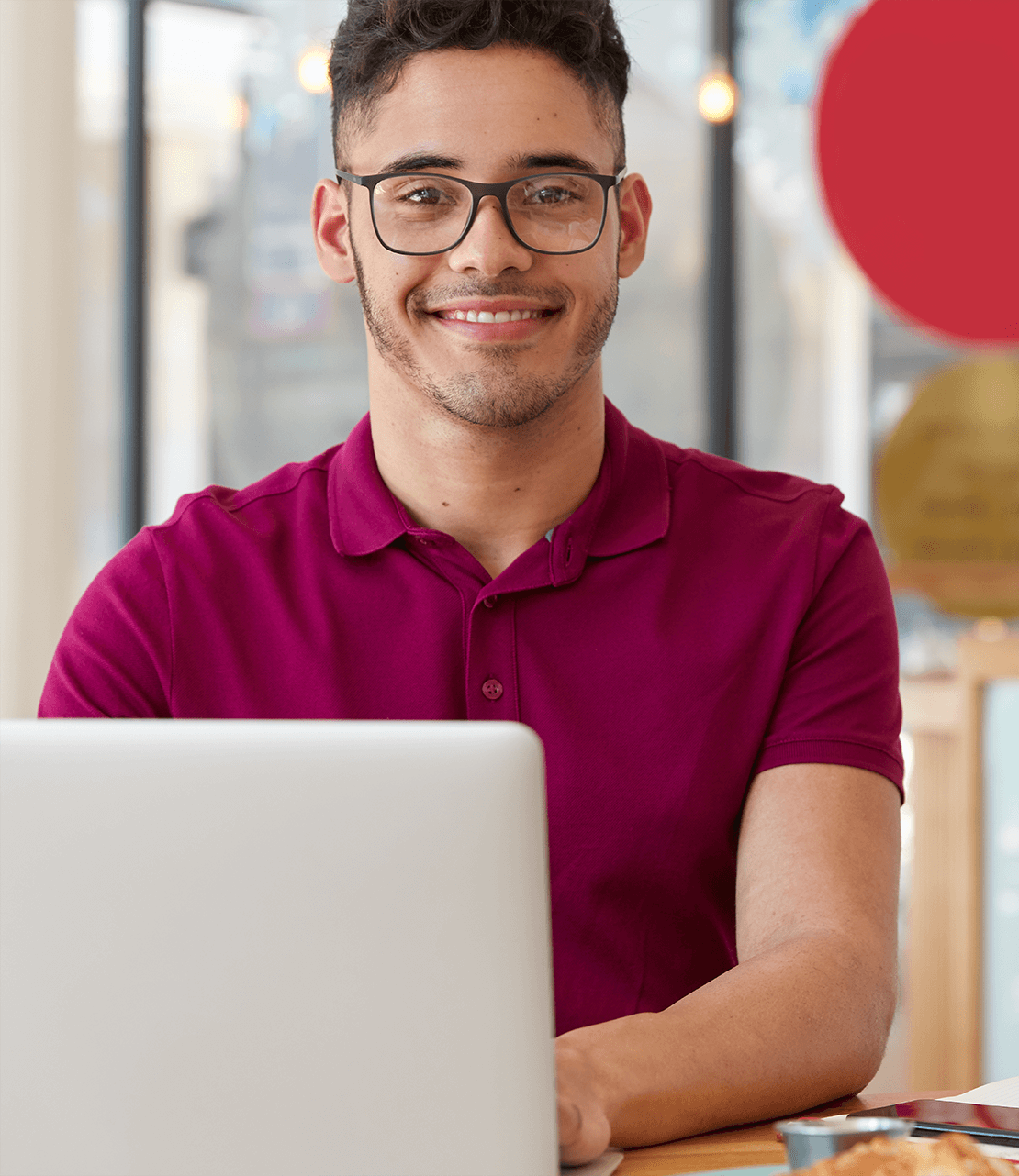 c5mjq_1110_pleasedcheerfulyoungmanchatsonlinewithfriendsfromabroadsitsfrontlaptopcomputerconnected4ginternetcoffeeshopwearsopticalglassesgoodvisionlikeshisjob